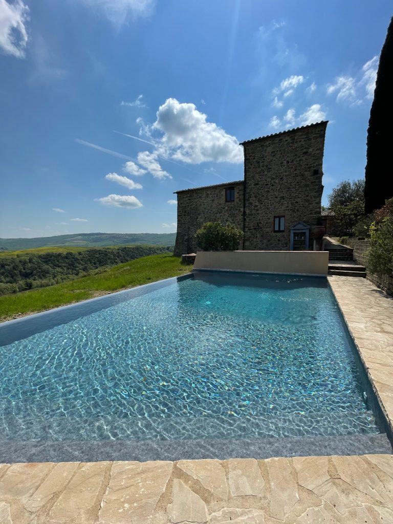 Piscina a sfioro accanto a un casale in pietra
