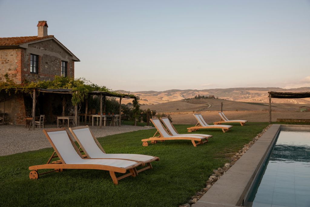 Piscina con solarium affacciata sulle colline